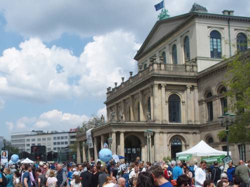 Viele Menschen auf einem Platz vor einem alten Gebäude, der Oper in Hannover